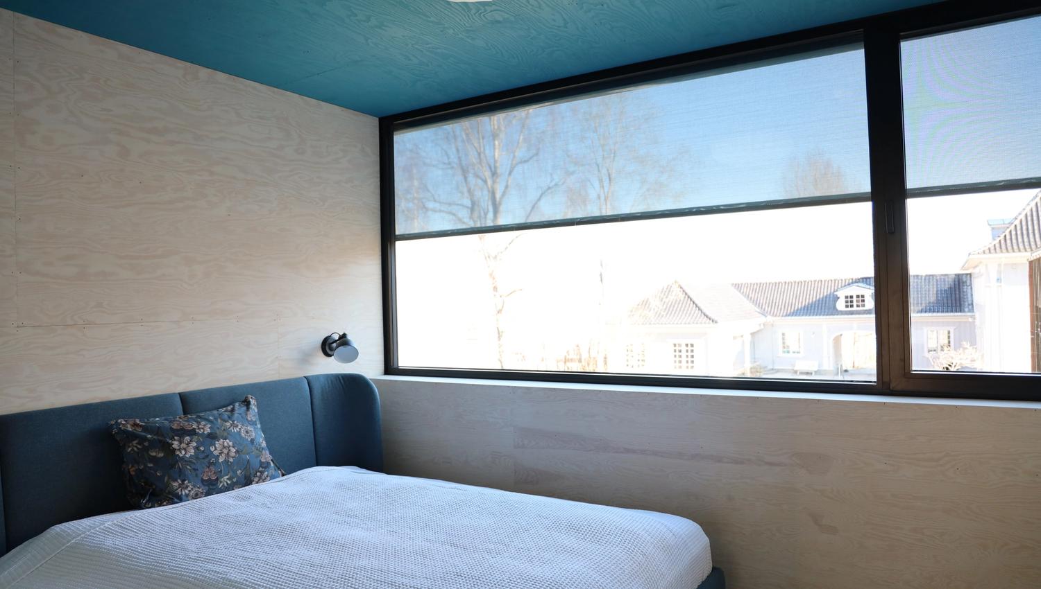 Wergelandshaugens microhus blått hus innvendig med soverom vinduer og kjøkken