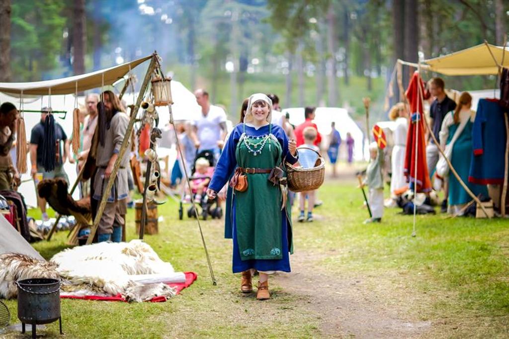 a woman walking down a path dressed in vikingclothes 