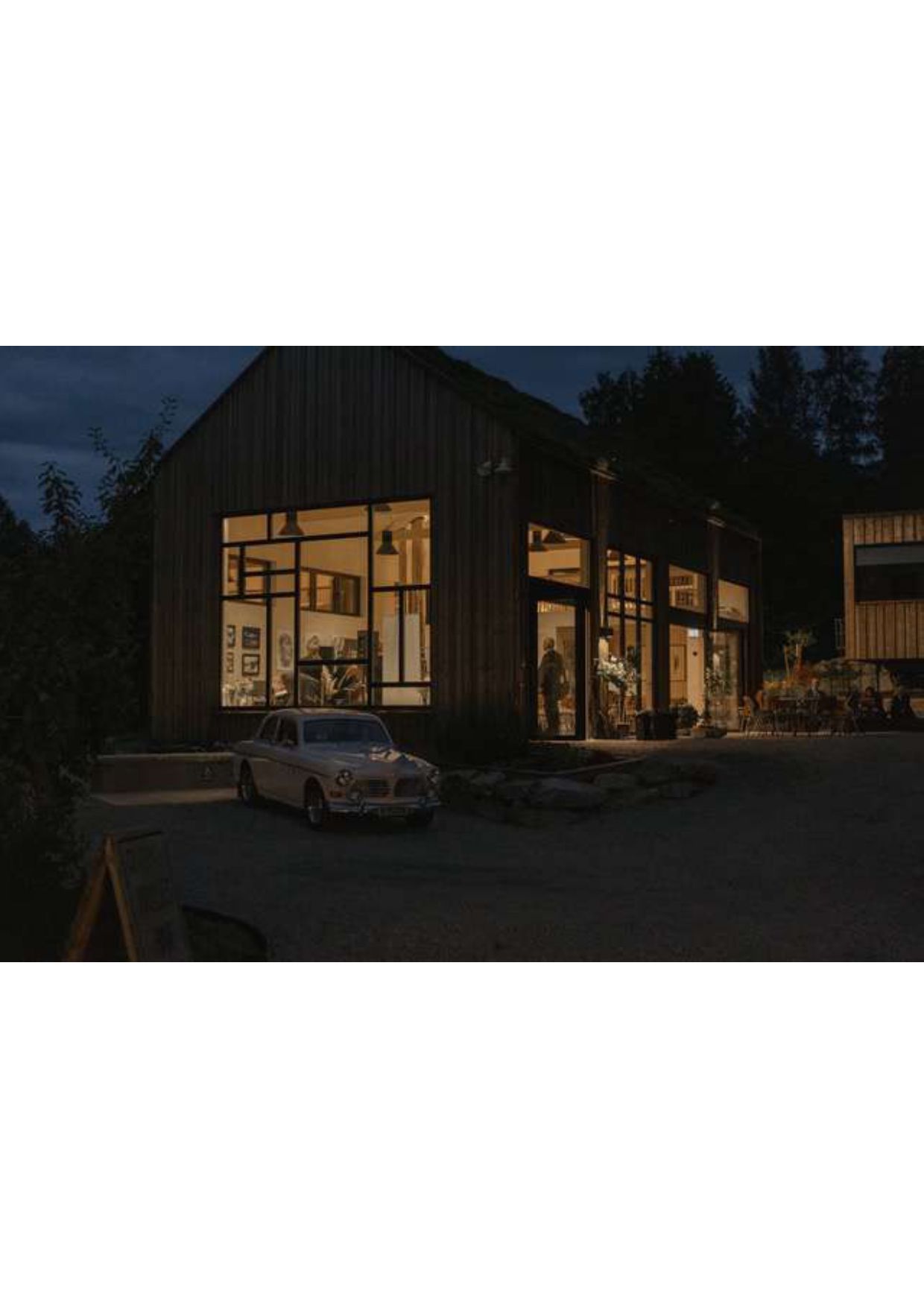 hus sett utenfra med lys og mennesker innvendig