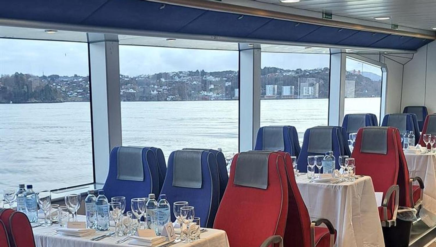 Set tables inside a boat with views overlooking the fjord