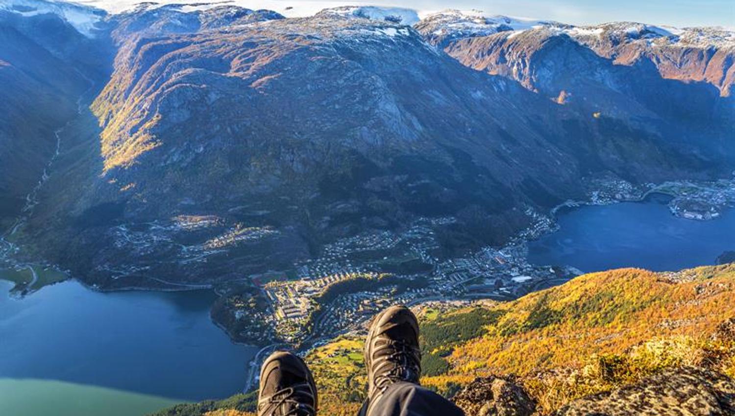 View over Odda and the fjord from the mountains, with autumn colours and dramatic peaks.
