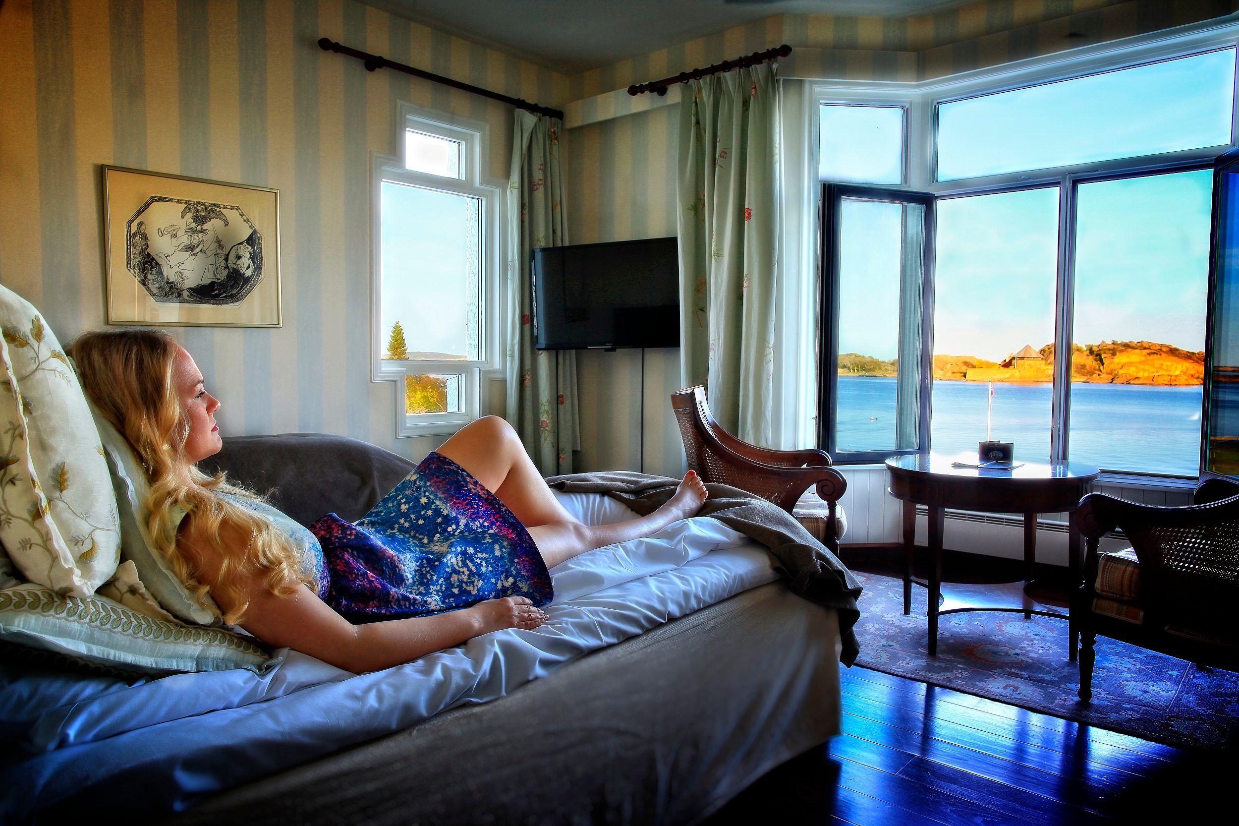 One who relaxes in bed and looks out the window at the view