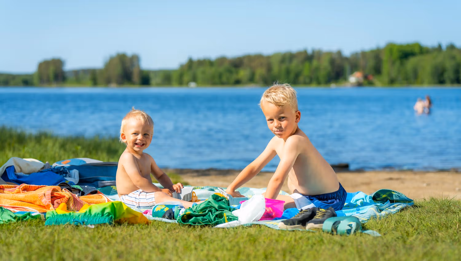 To smågutter som koser seg på hånddukene sine etter en dukkert.