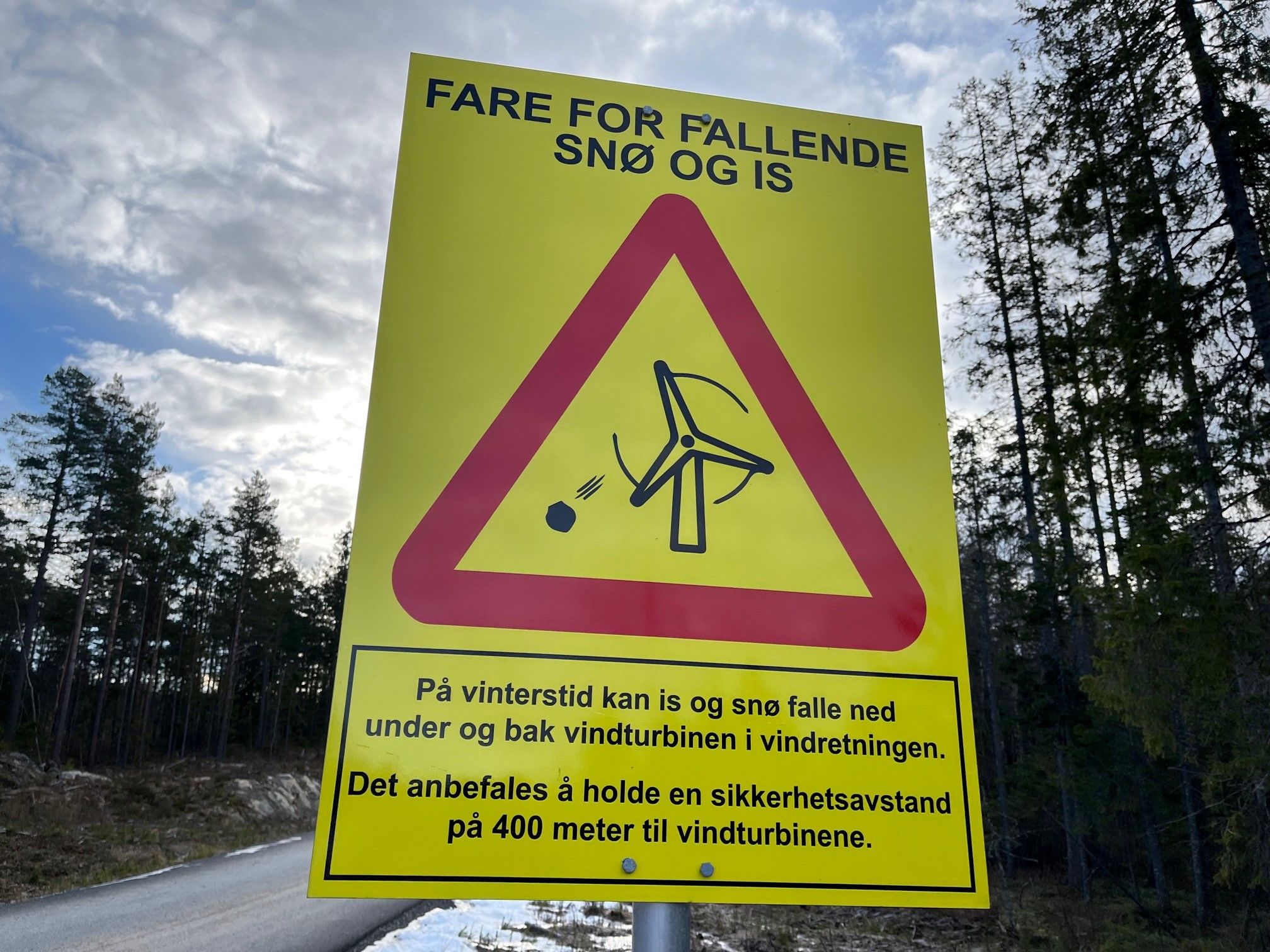 Skilt som forteller farene ved snø og is om man går nære vindmøllene