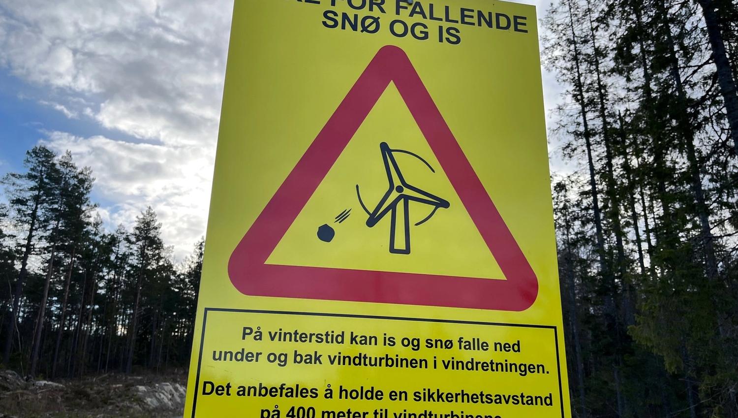 Skilt som forteller farene ved snø og is om man går nære vindmøllene
