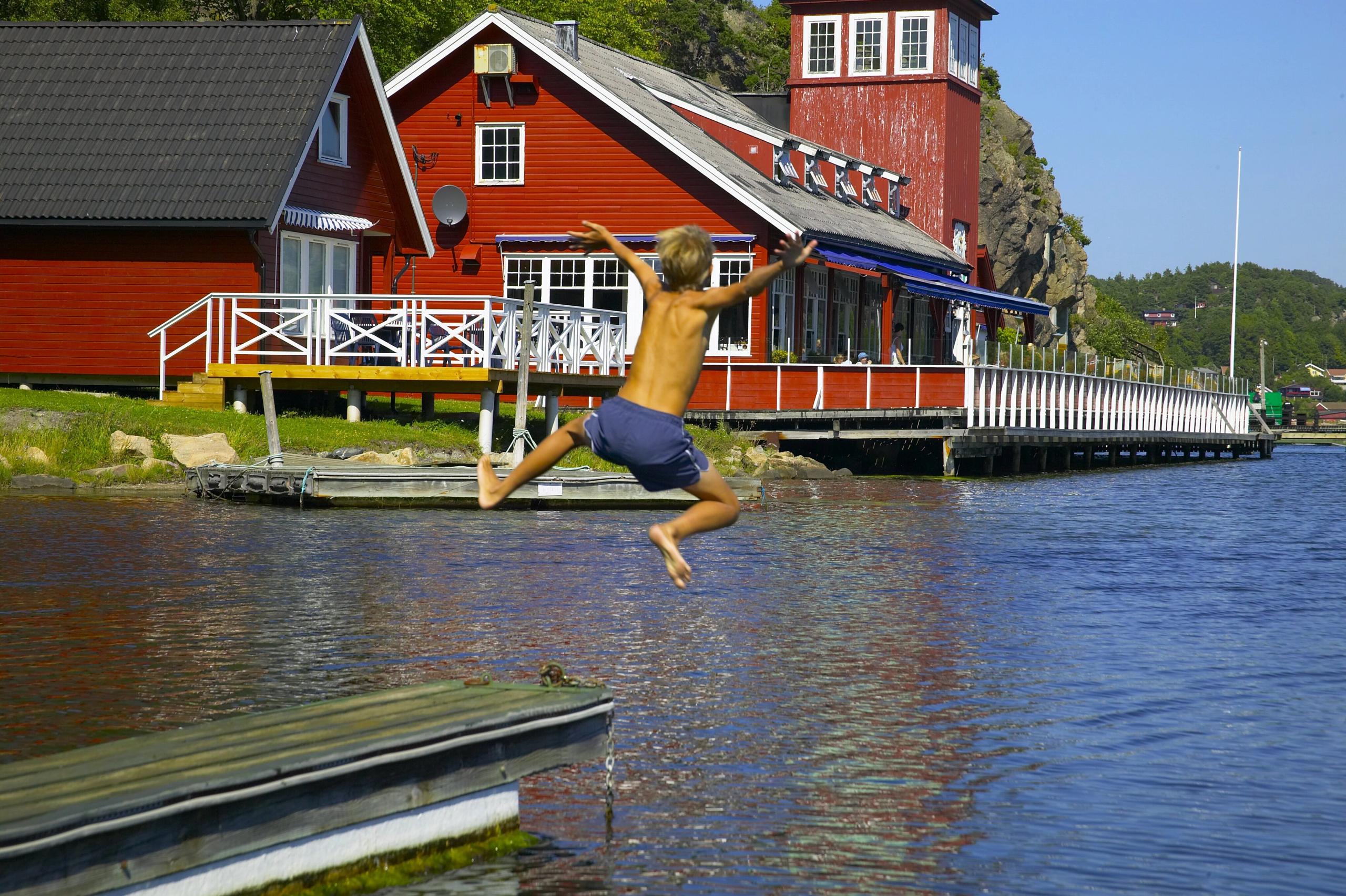 Glad gutt hopper i sjøen