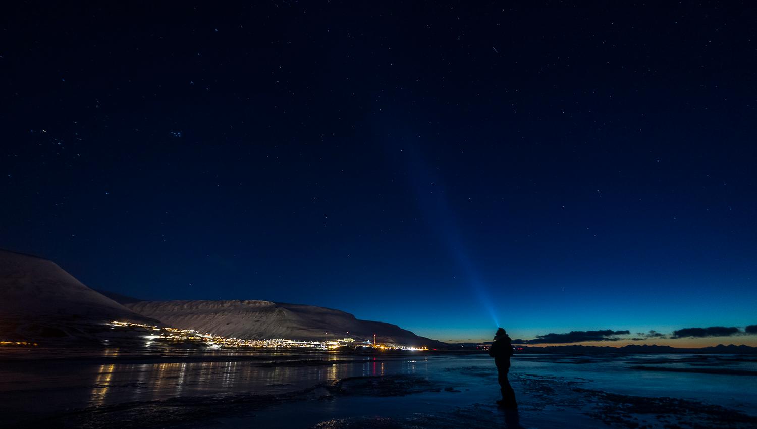 A person looking for northern lights outside of Longyearbyen