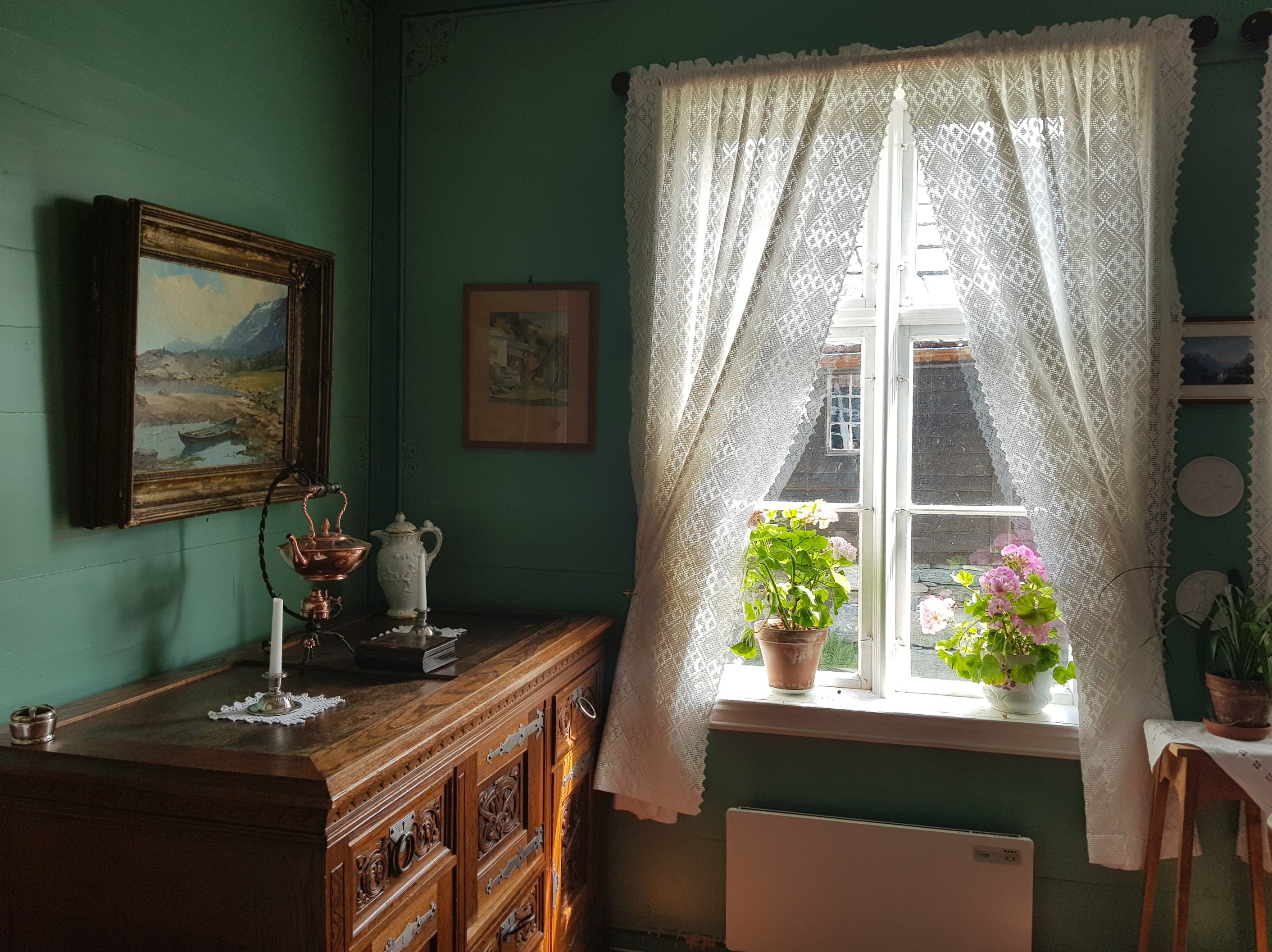 A window with flowers and white lace curtains