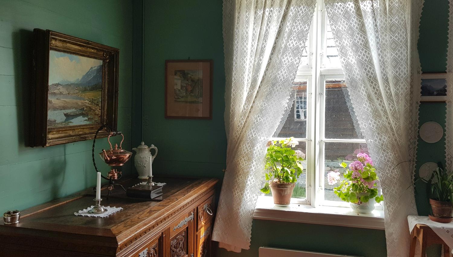 A window with flowers and white lace curtains