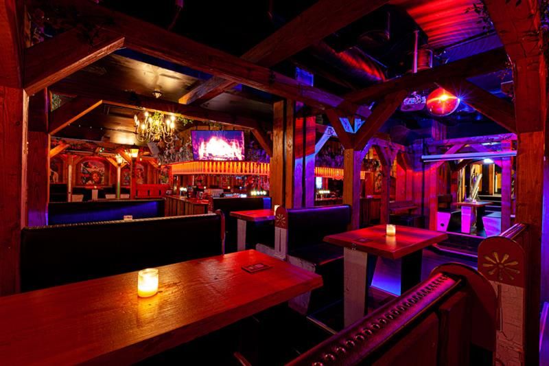 Bar interior with seating booths surrounded by neon lights