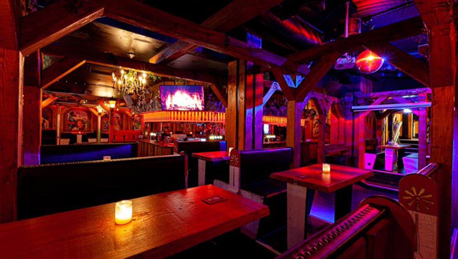 Bar interior with seating booths surrounded by neon lights