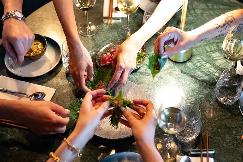 Hands reaching for a sharing menu