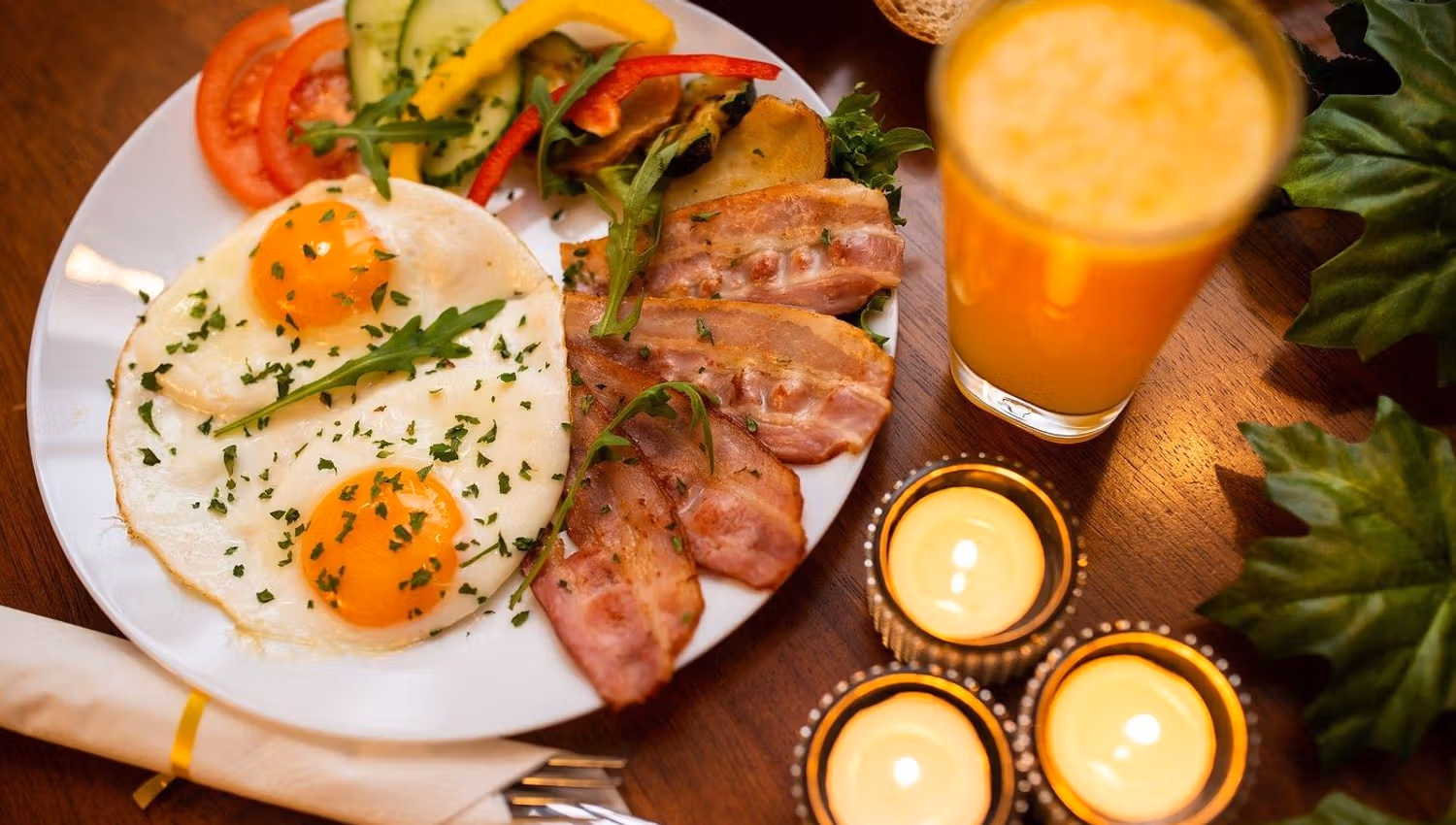 Breakfast with eggs, bacon, vegetables and a drink served at Koseverden in Tromsø.