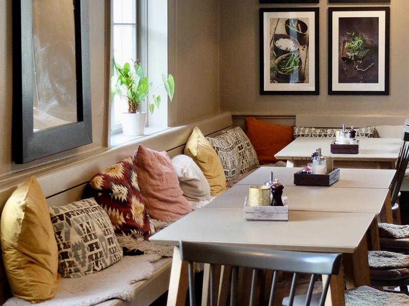 Table and bench with pillows in restaurant