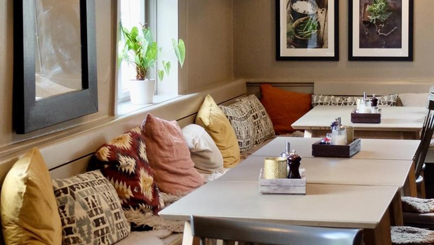 Table and bench with pillows in restaurant
