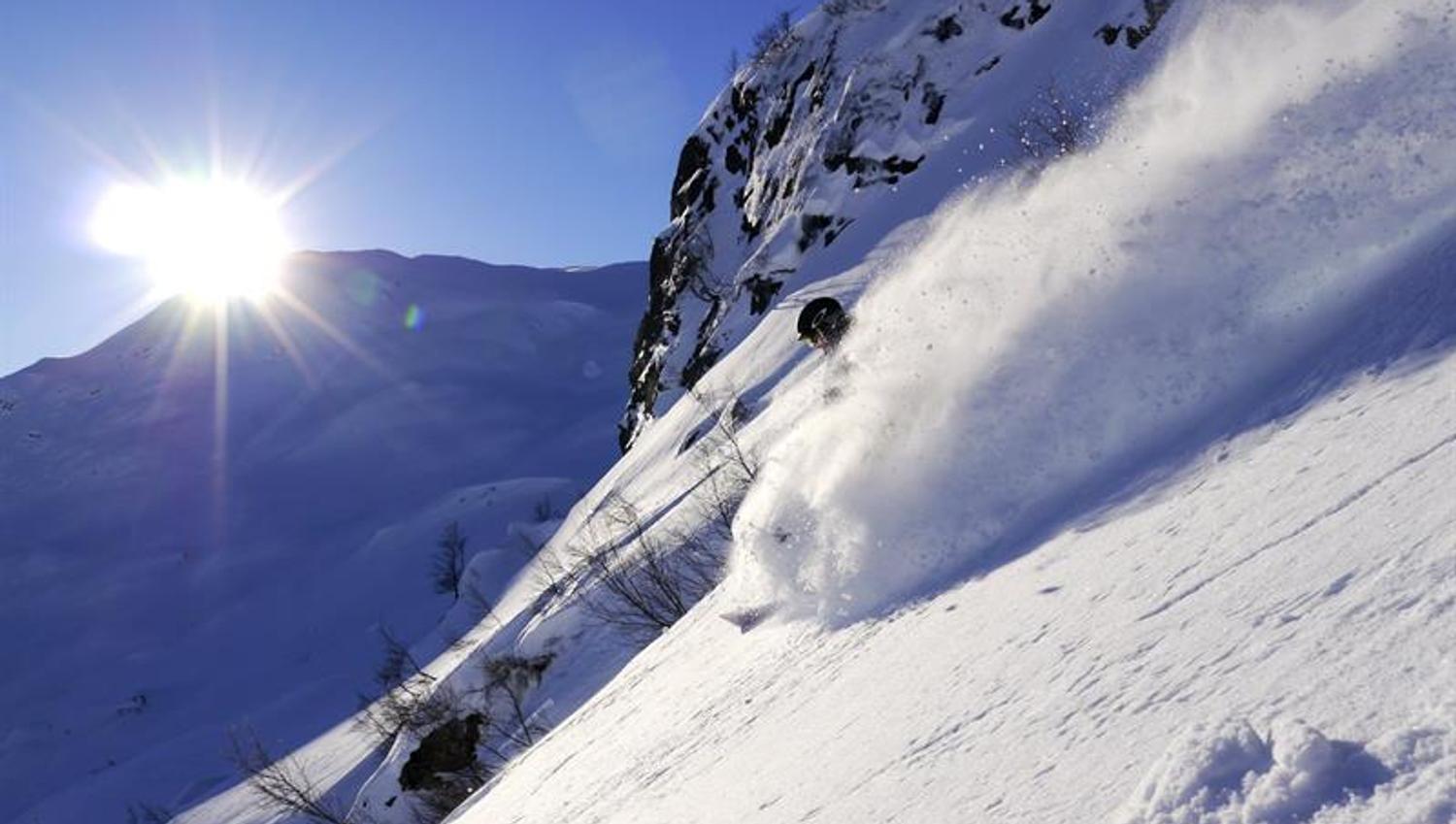 Freerider gleitet durch tiefen Pulverschnee im Sonnenuntergang im Røldal Skigebiet.