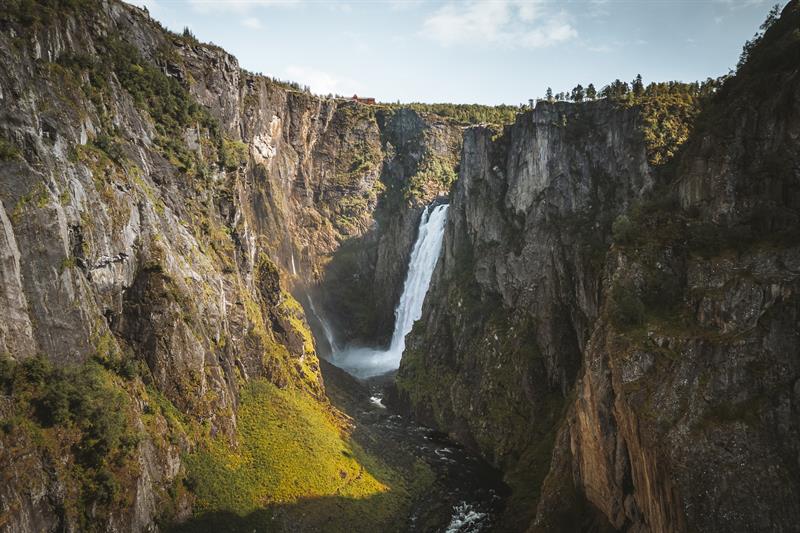 A drone shot from high above the new bride, the waterfall is seen in the background.