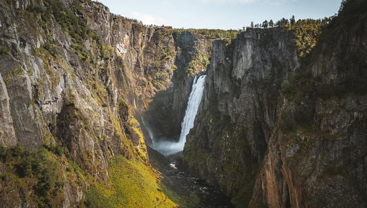 A drone shot from high above the new bride, the waterfall is seen in the background.