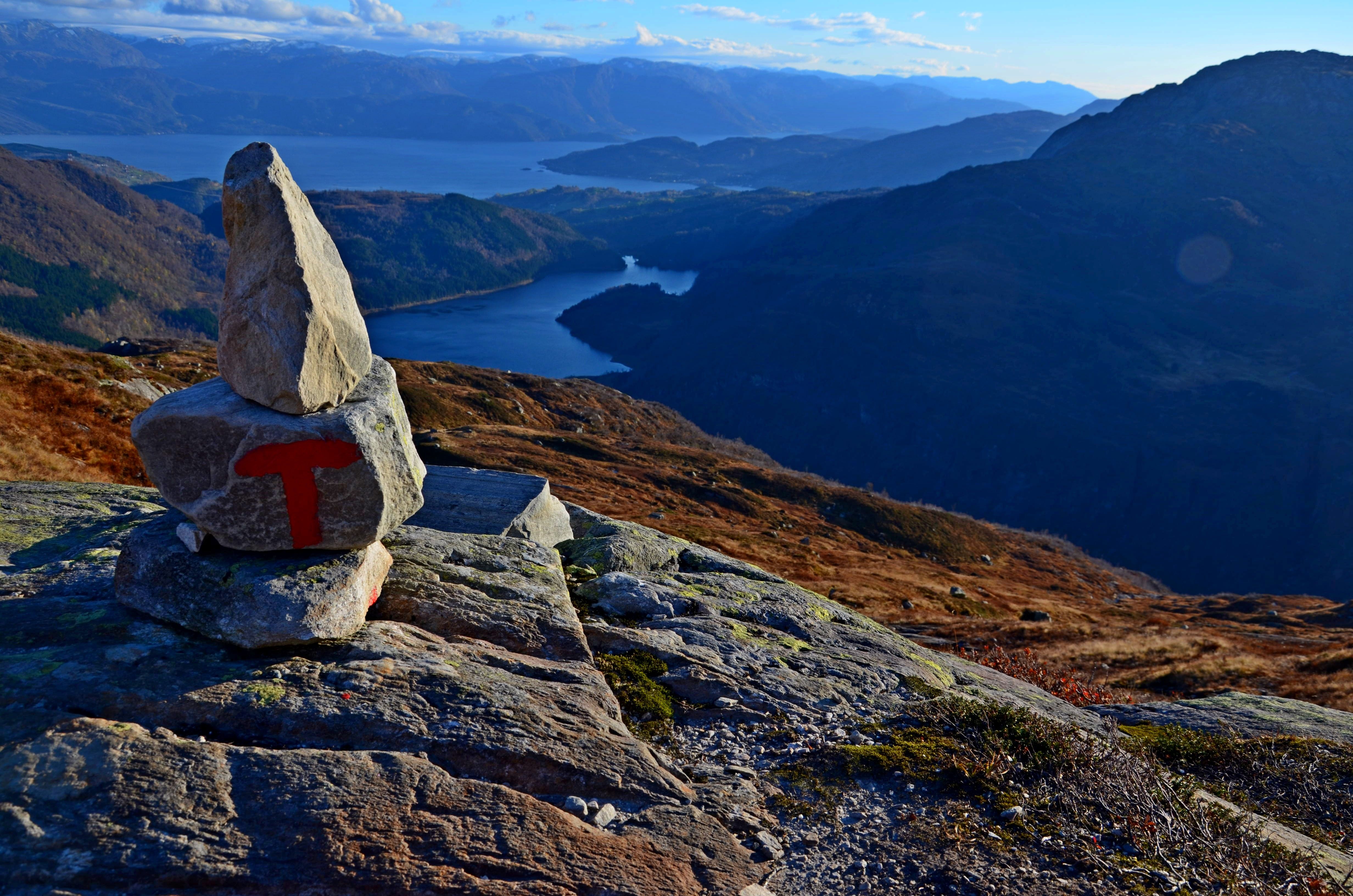 Red-marked trail cairn overlooking Fitjadalen and the dramatic Hardanger fjord landscape.