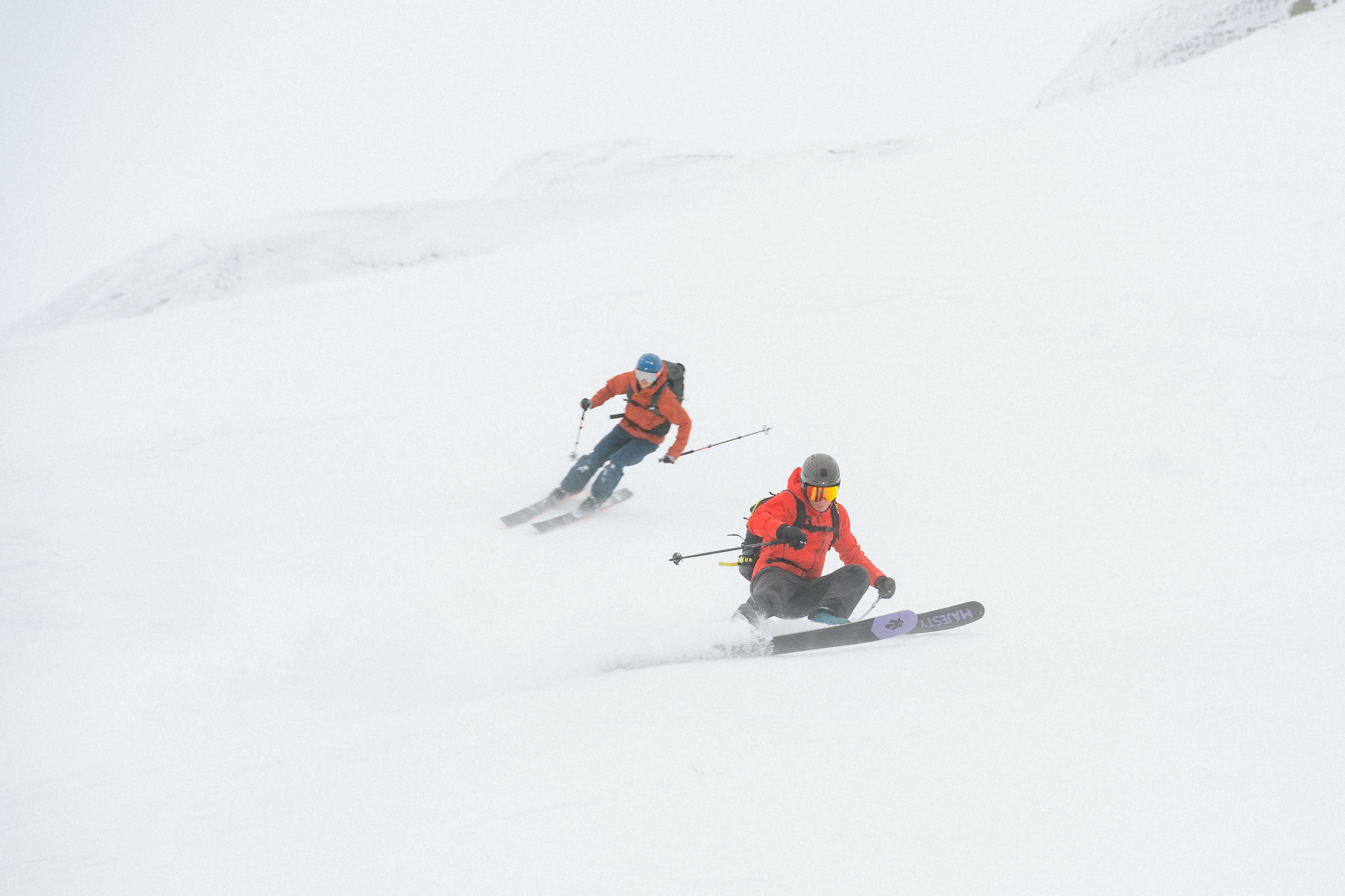 Two men speed skiing down a slope. 