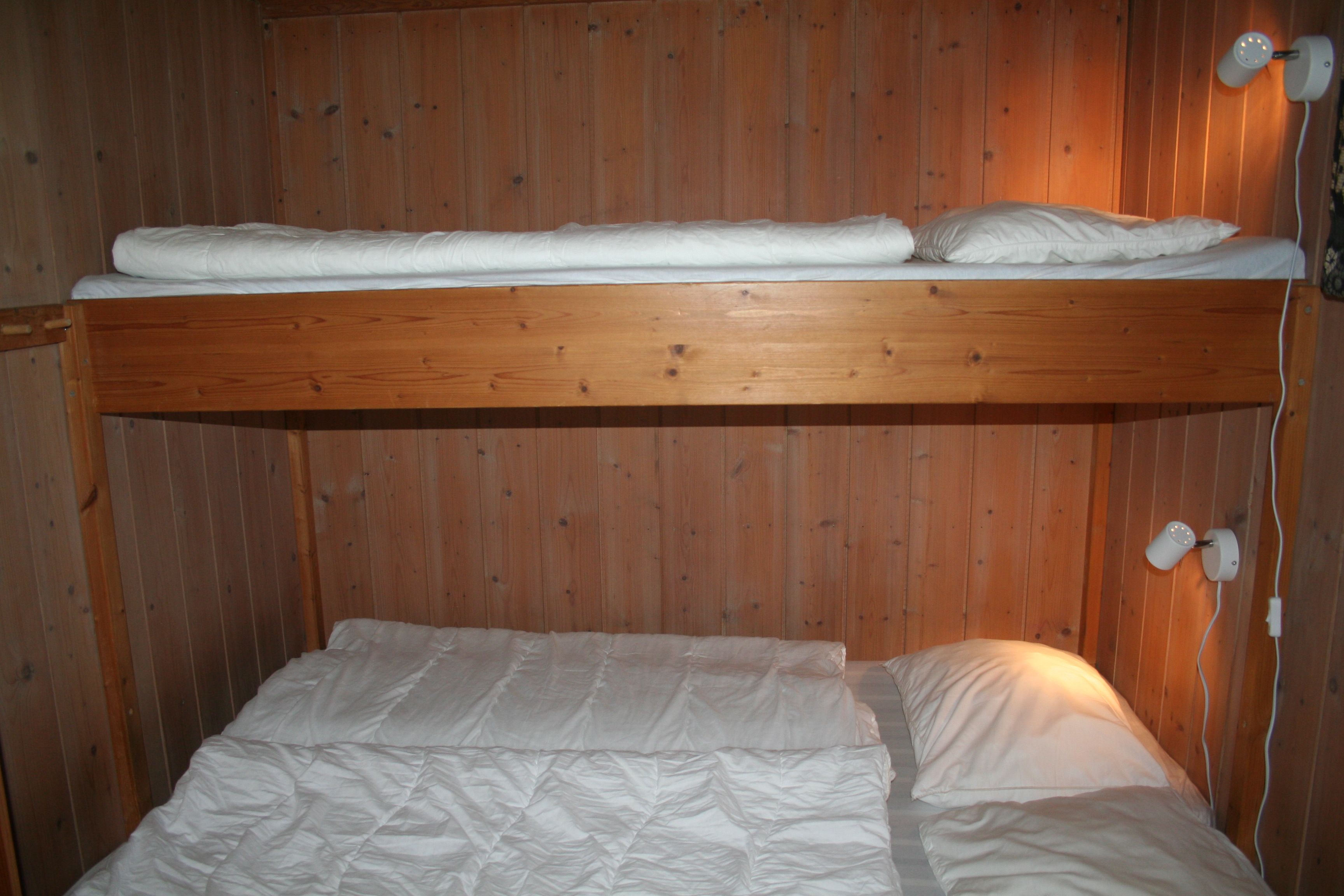 Cozy bedroom with bunk bed and wooden interior in a cabin at Hardanger Feriesenter.