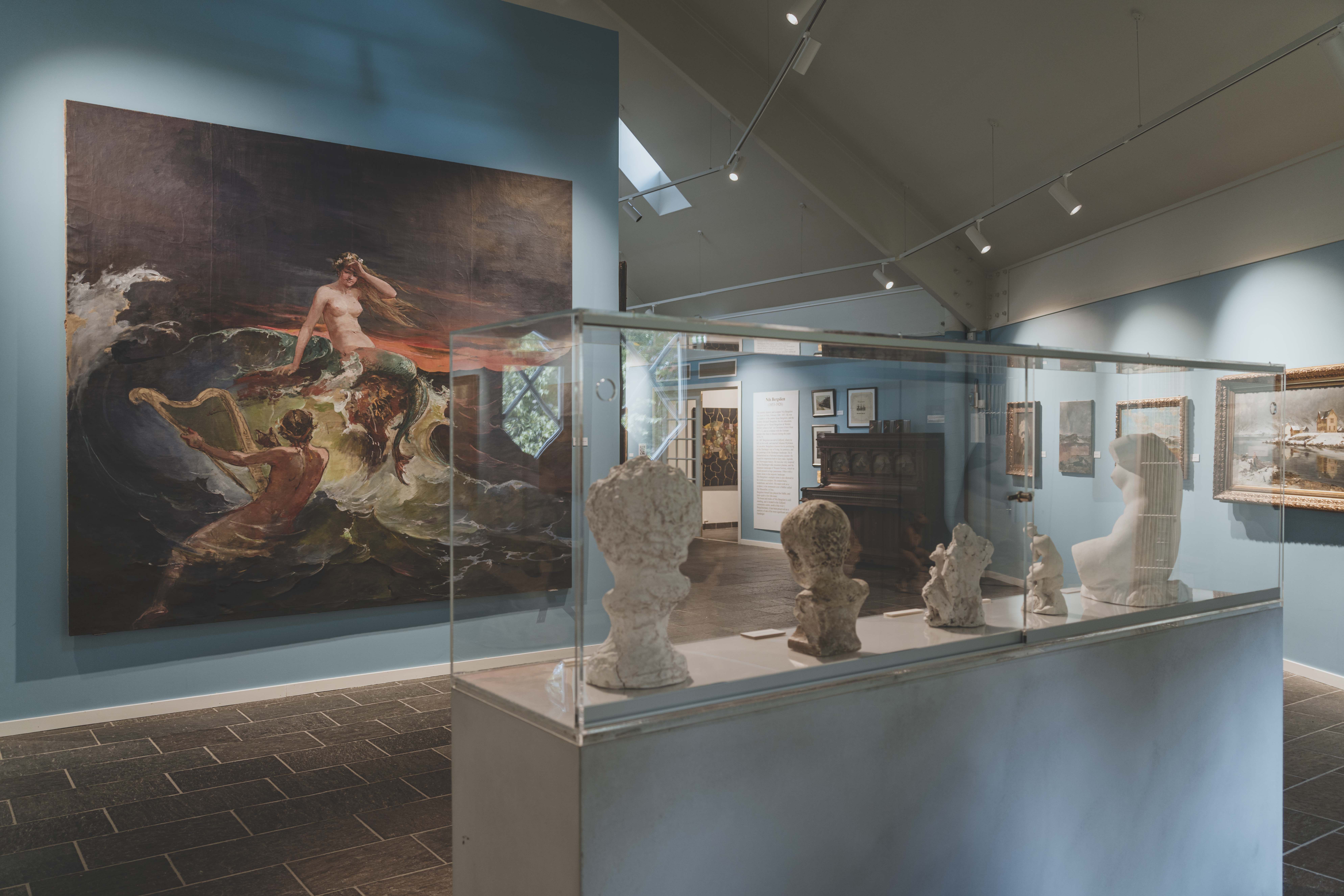 A stand with statues, in the background is a large mural with a mermaid.