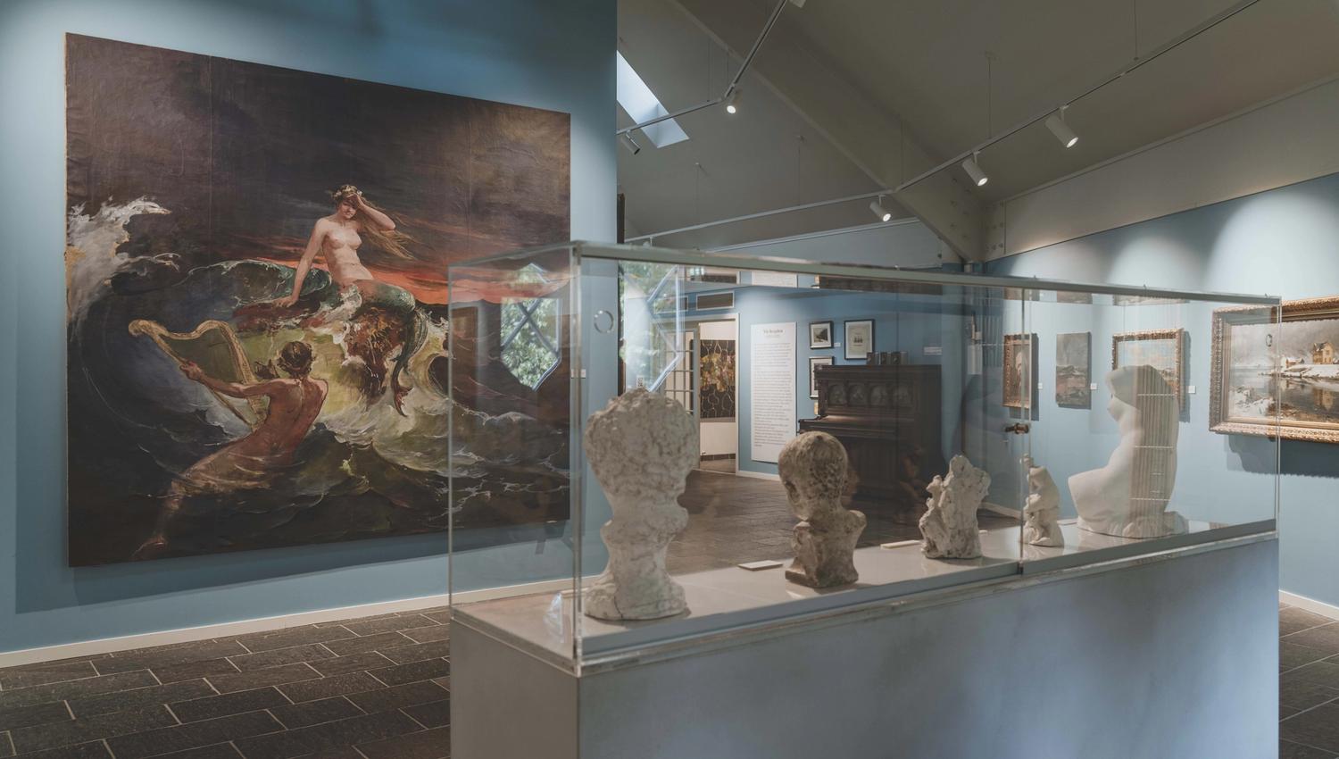 A stand with statues, in the background is a large mural with a mermaid.