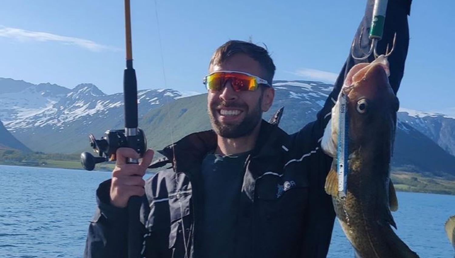 Gjest viser fisk han har fått.