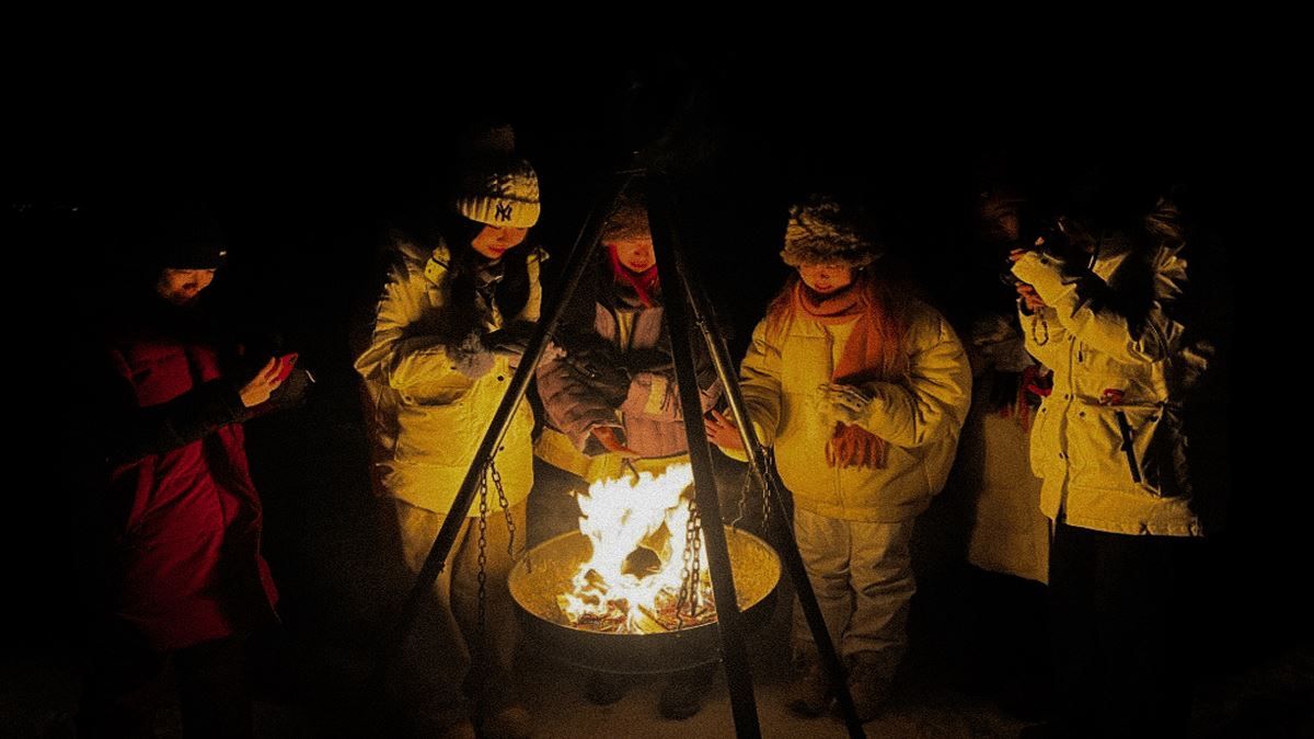 A group of guests sitting around a bonfire