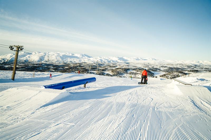 snowboarder drives on terrain park at Rauland ski center 