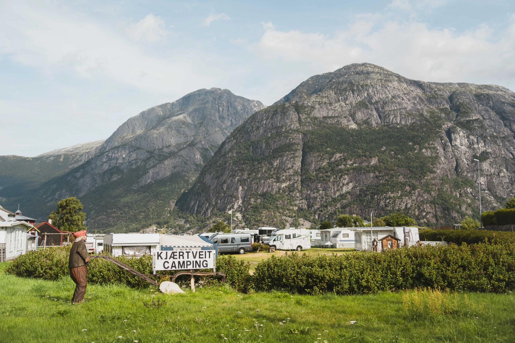 A wooden figure and the Kjærtveit sign, seen in front of the camground.