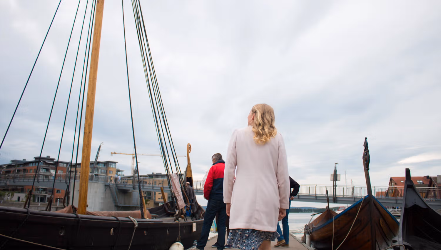 Folk på brygga som ser på vikingskipet som ligger ved brygga i Tønsberg