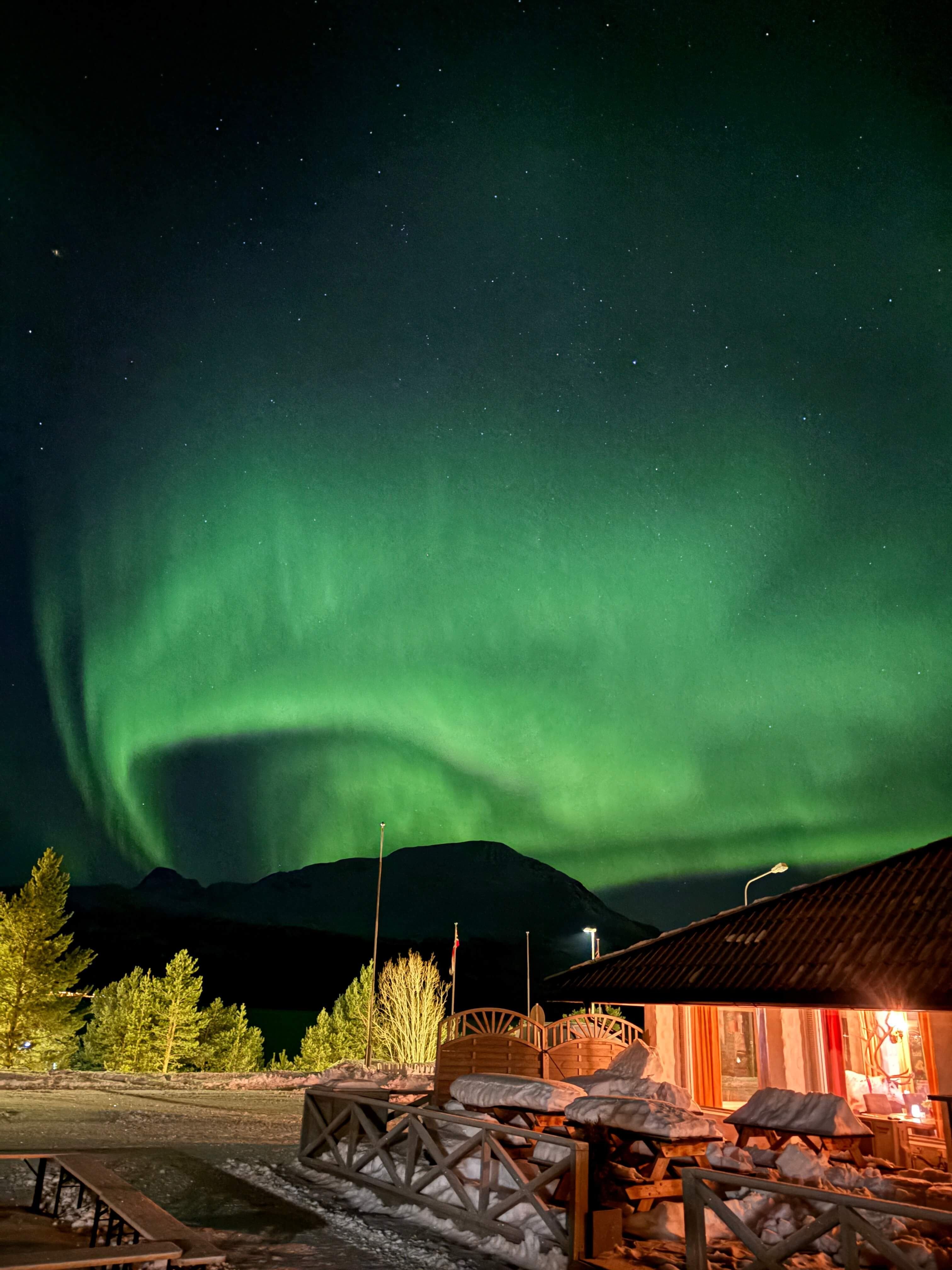 Strong northern lights directly above the hotel