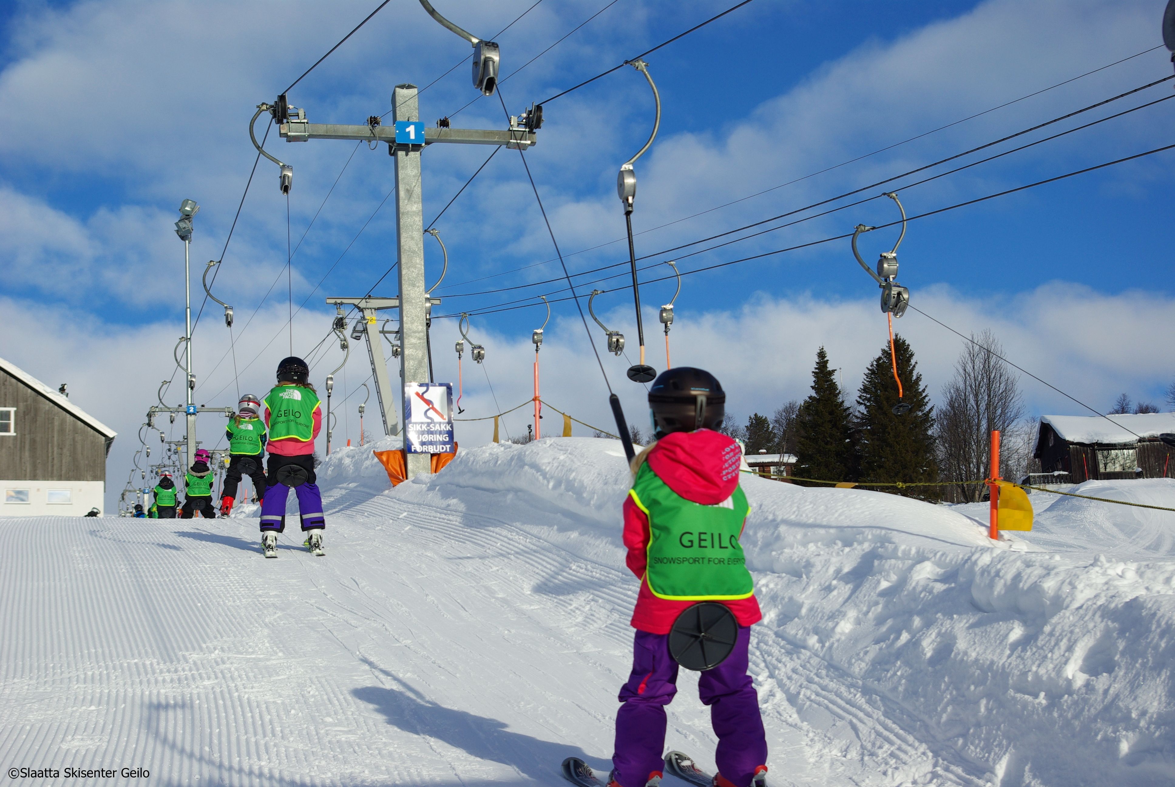 Barn på skiskole som tar heis