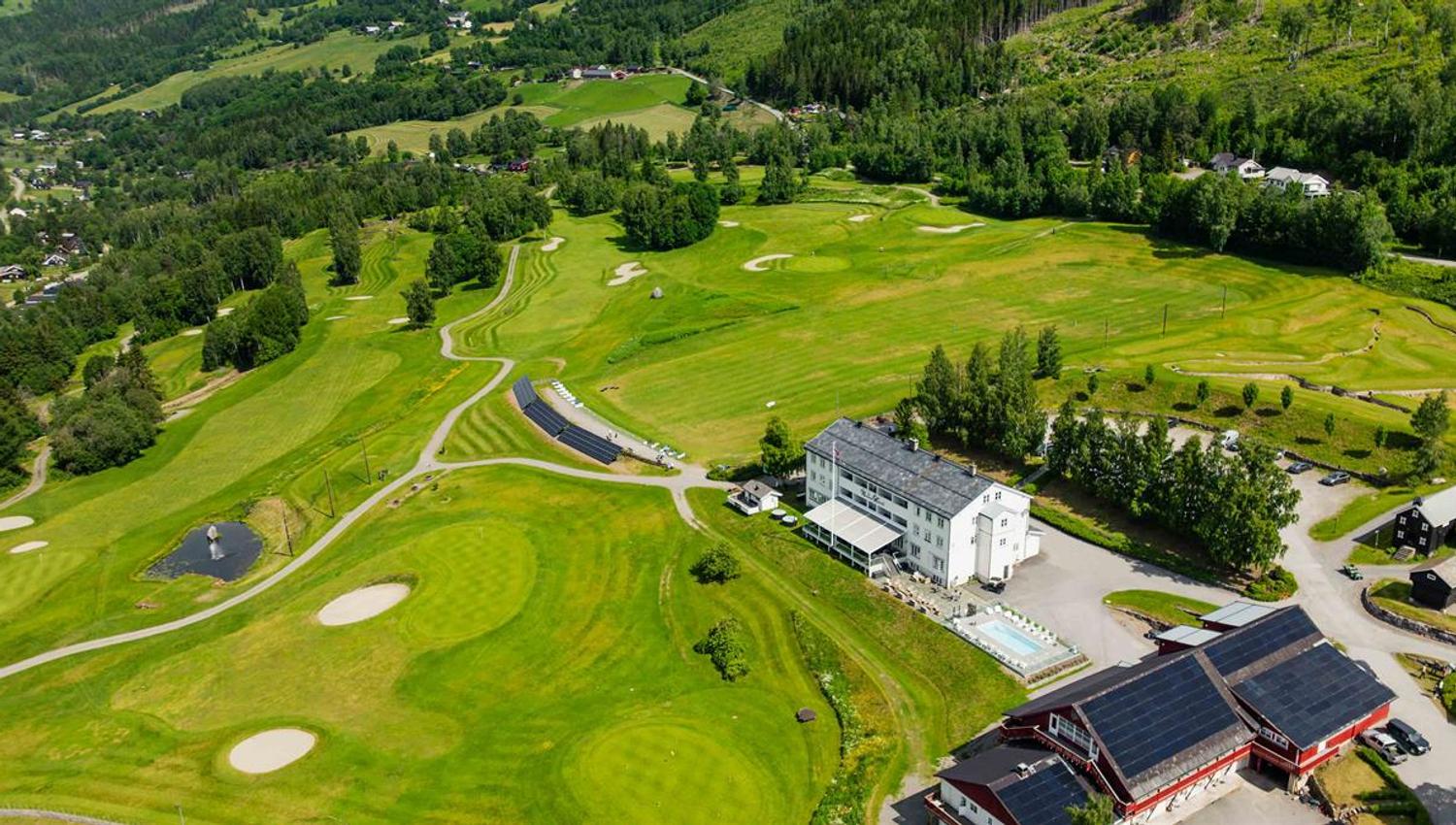 Aerial view of a golf course in a valley landscape.