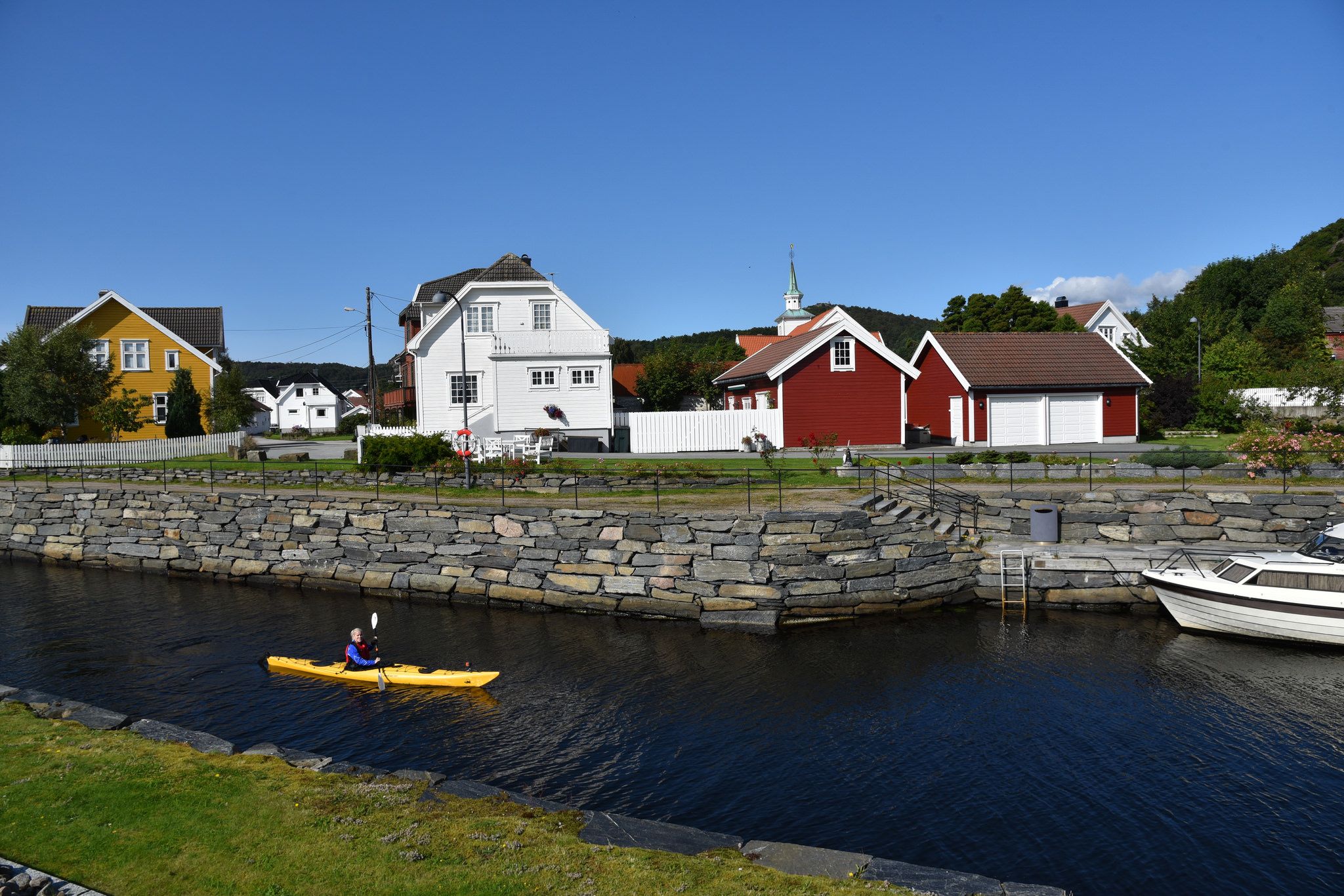 En person i en gul kajakk som padler i Spangereidkanalen