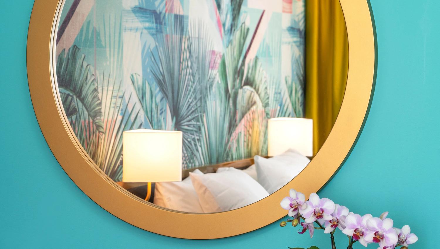 Round mirror on green wall. Flowers. Thon Hotel Storo, Oslo. Photo