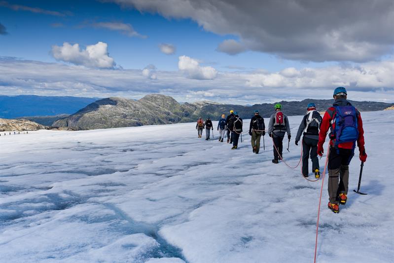 Gruppe på guidet brevandring over Folgefonna med utsikt mot fjell og dalar i Hardanger.