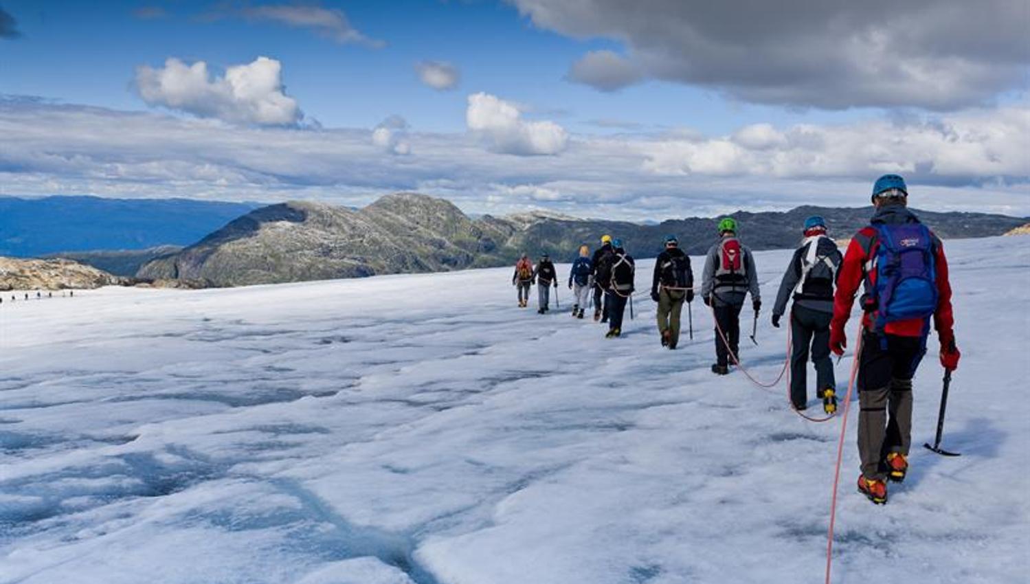 Gruppe på guidet brevandring over Folgefonna med utsikt mot fjell og dalar i Hardanger.