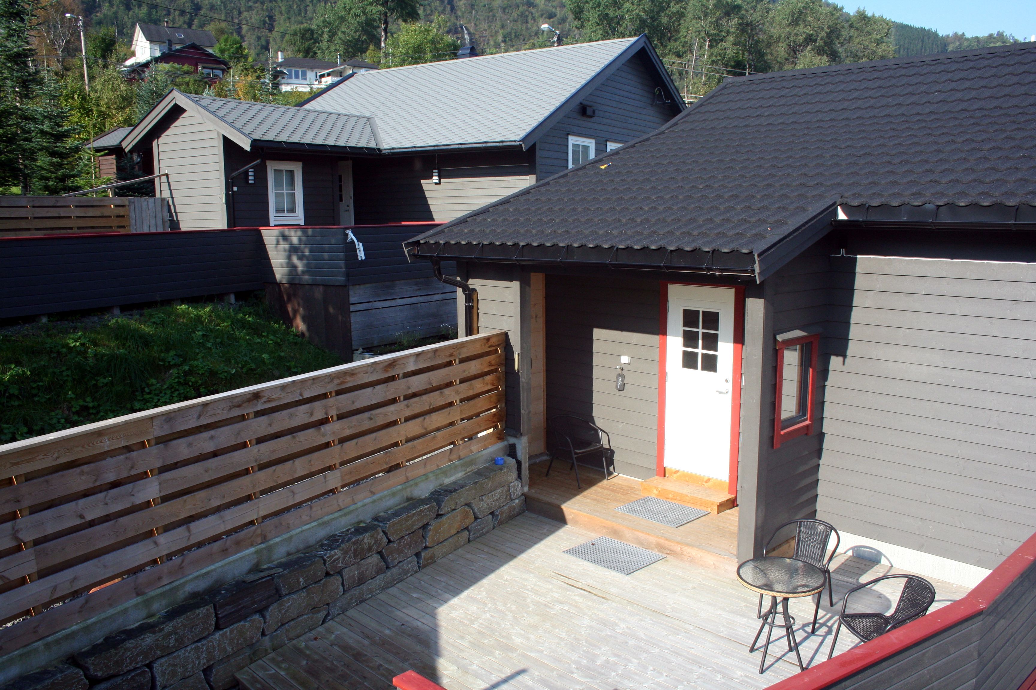 Terrace area at Vågen Rooms and Cabins with entrance door and outdoor seating.