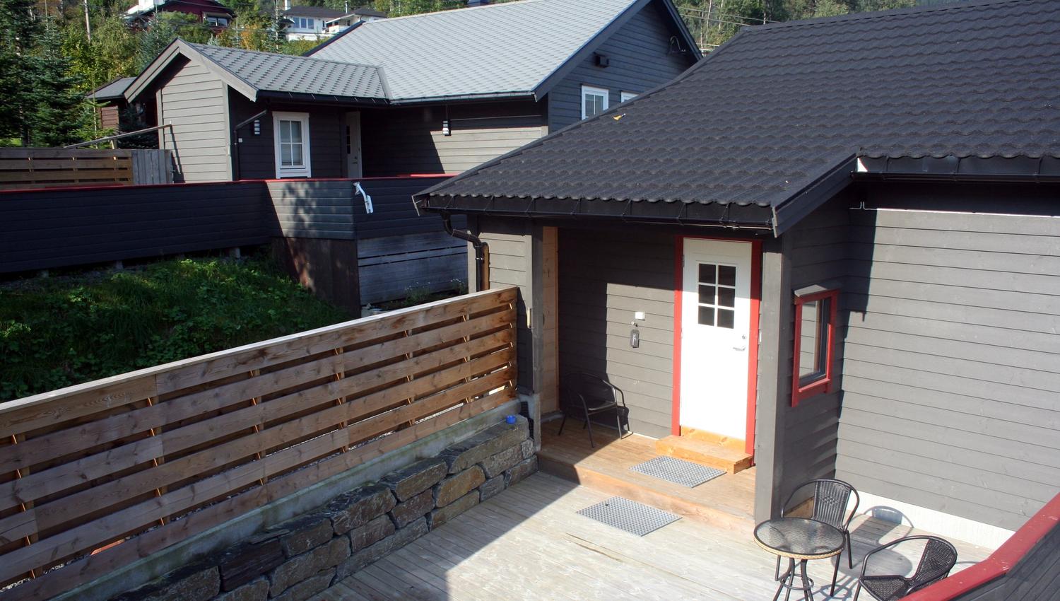 Terrace area at Vågen Rooms and Cabins with entrance door and outdoor seating.