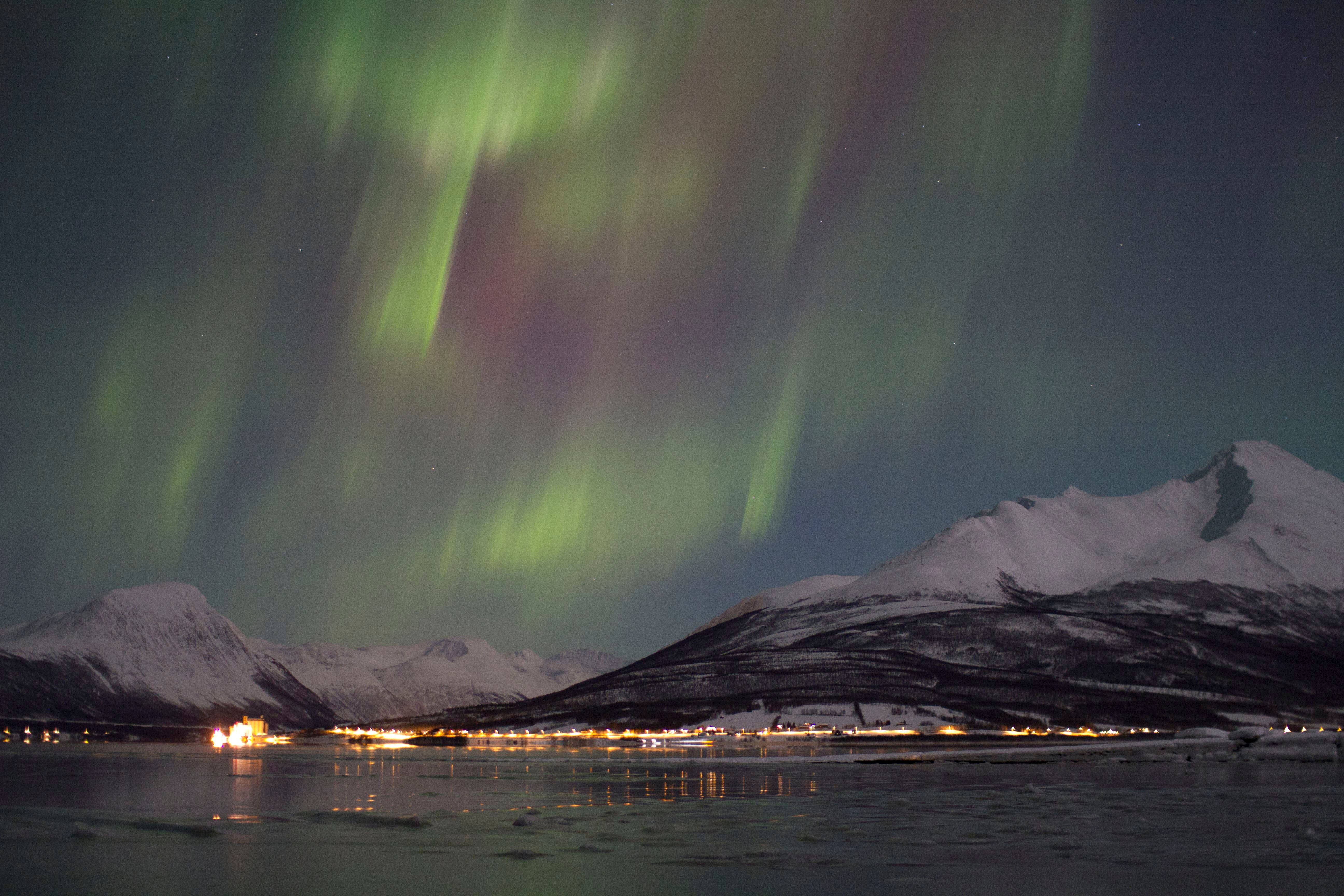 nordlys over fjellandsskapet ved fjorden