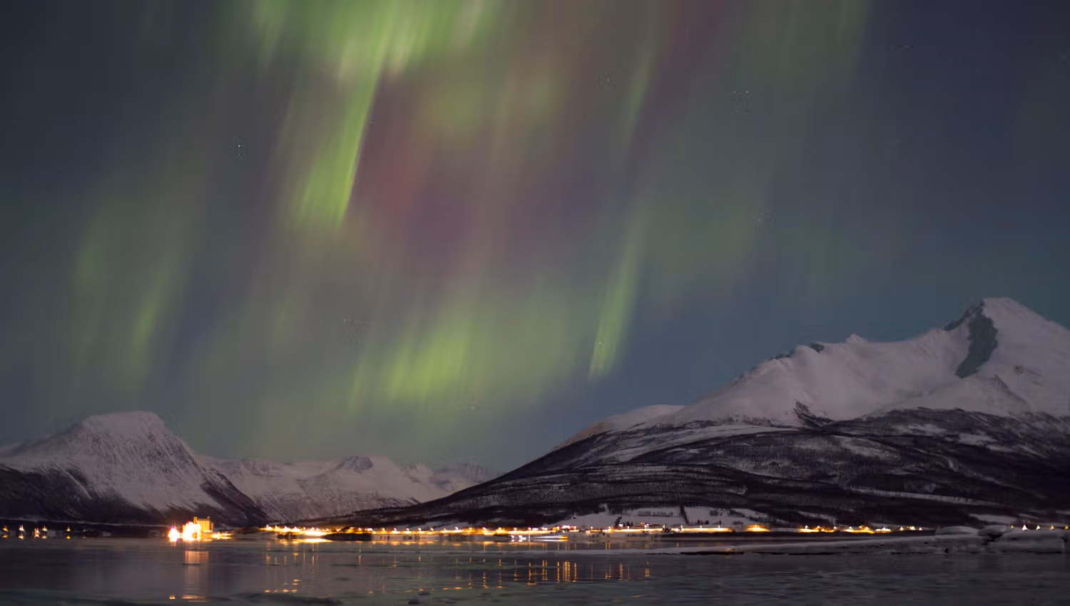 nordlys over fjellandsskapet ved fjorden