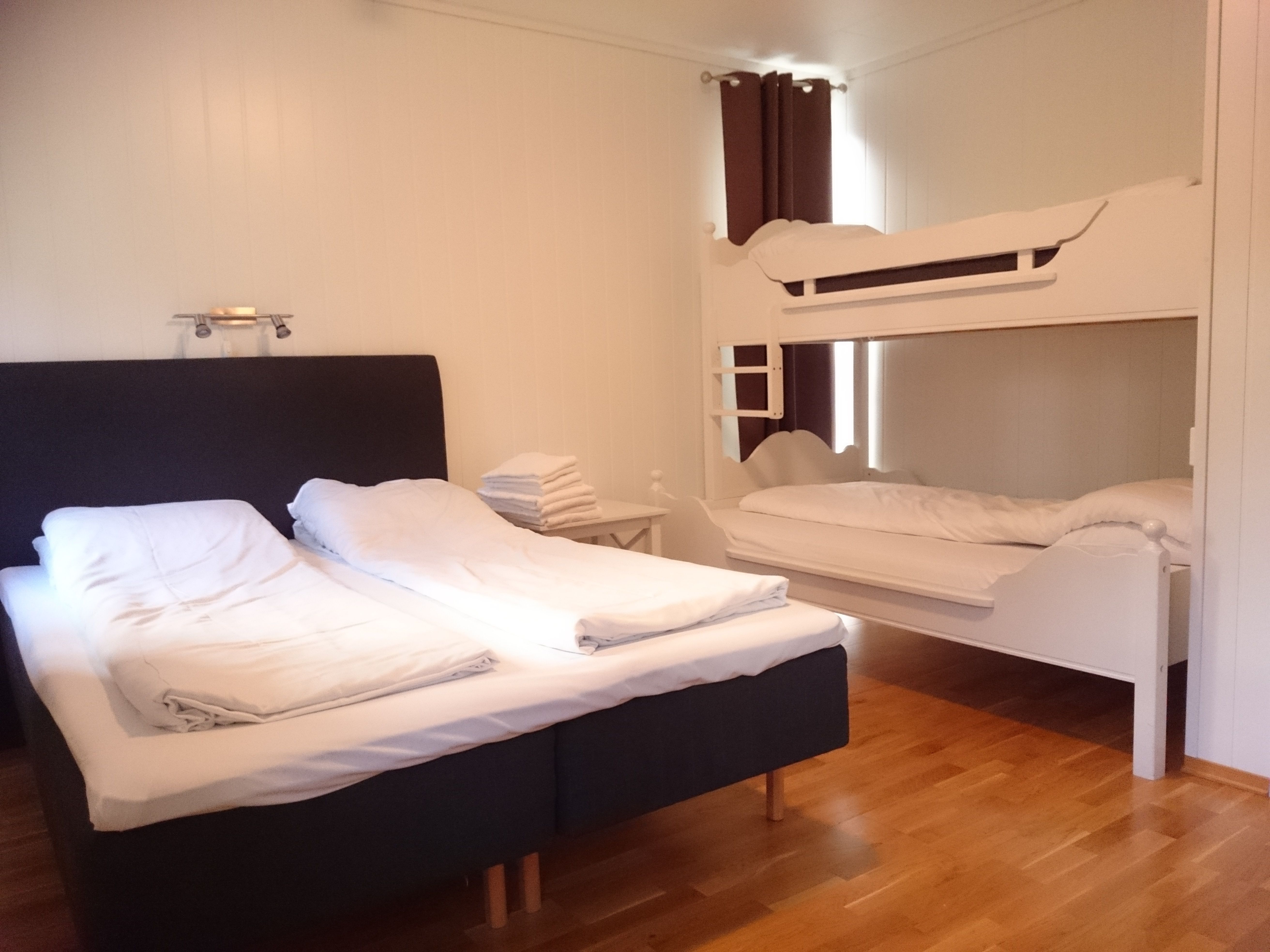 Bright and modern bedroom at Ullensvang Gjesteheim with a double bed, bunk bed and comfortable space for families.
