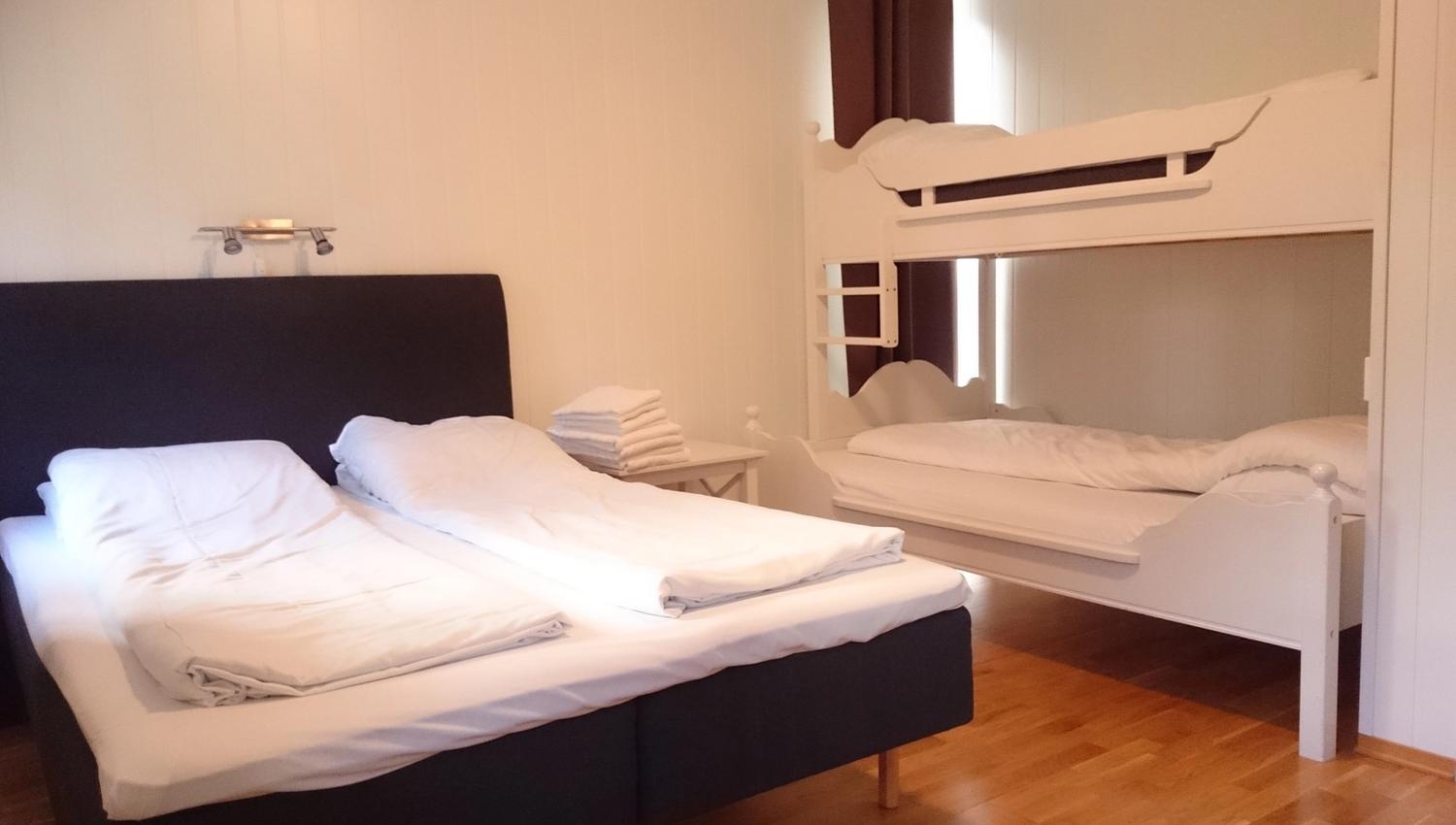 Bright and modern bedroom at Ullensvang Gjesteheim with a double bed, bunk bed and comfortable space for families.