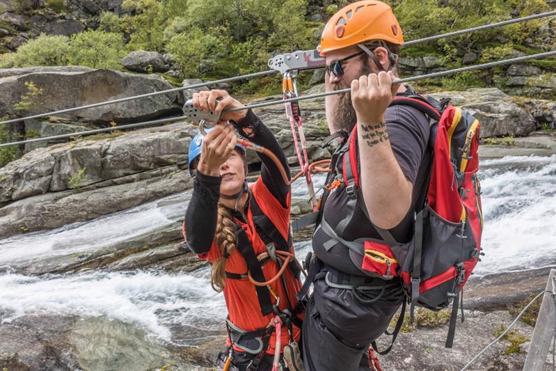 Guide hjelper deltakar med sikkerheitsutstyr før Trolltunga Zipline på guida tur i Hardanger.