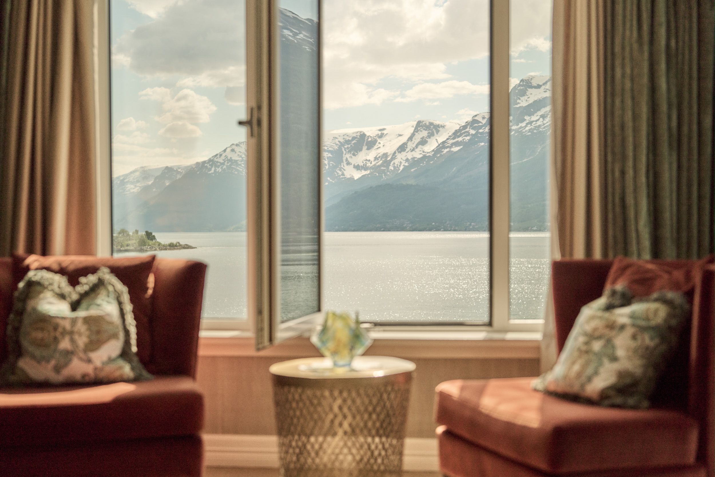 Comfortable seating area with open window and spectacular fjord view at Hotel Ullensvang.