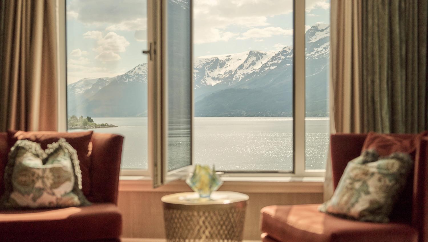 Comfortable seating area with open window and spectacular fjord view at Hotel Ullensvang.