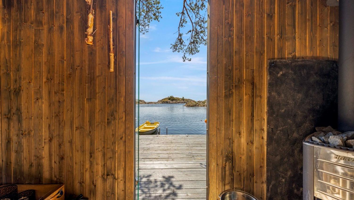 bilde tatt inne fra badstue med utsikt mot brygge og sjøen utenfor Tromøy.