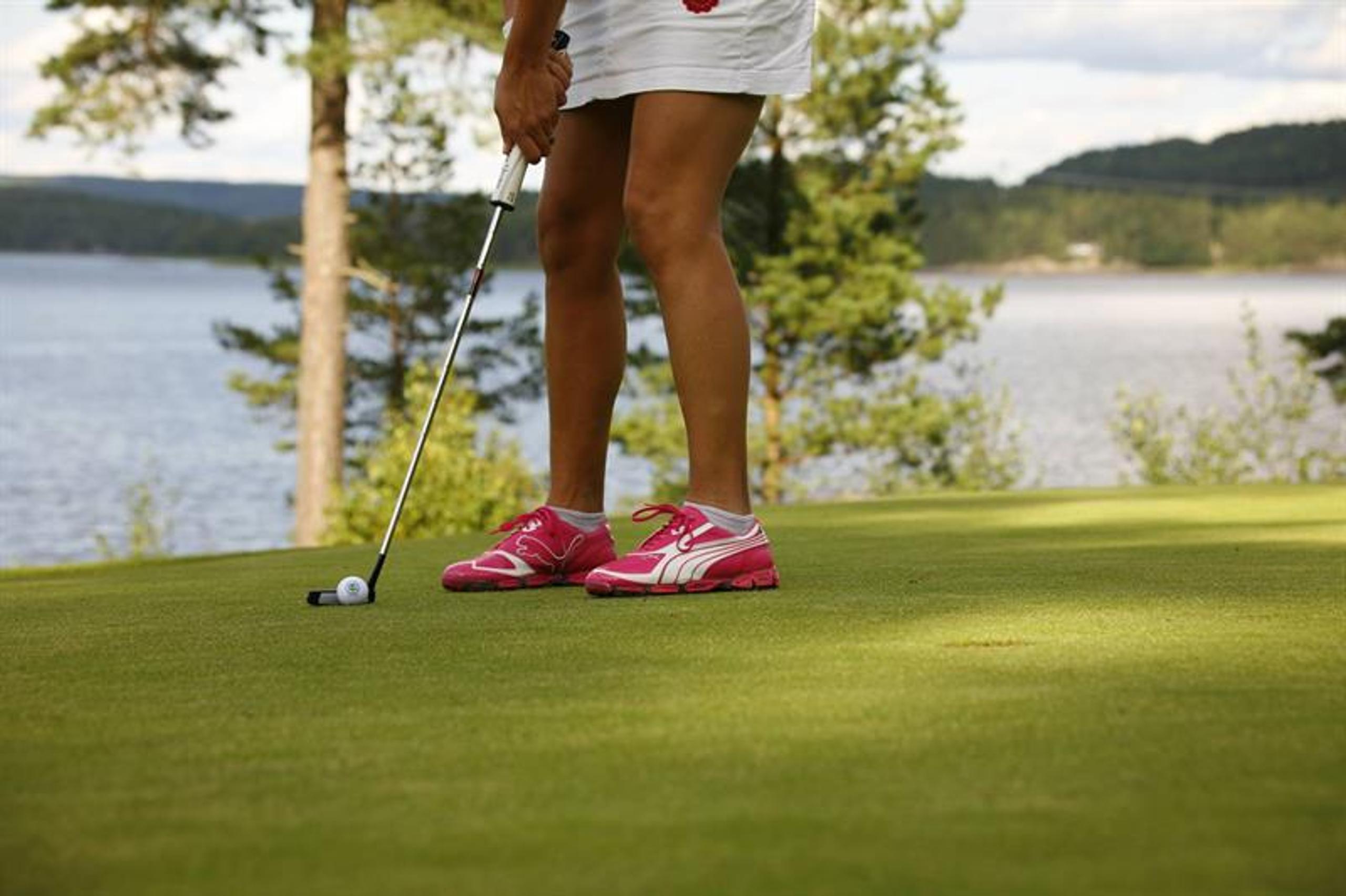 Kvinne som spiller golf på Skjeberg Golfklubb. Foto.